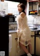 A woman standing in a kitchen next to a microwave.