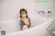 A woman sitting in a bathtub in a bathroom.