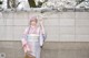 A woman in a kimono standing next to a wall.