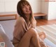 A woman sitting on a couch smiling at the camera.