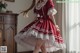 A woman in a red and white dress is posing for a picture.