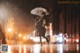 A woman walking in the rain holding an umbrella.